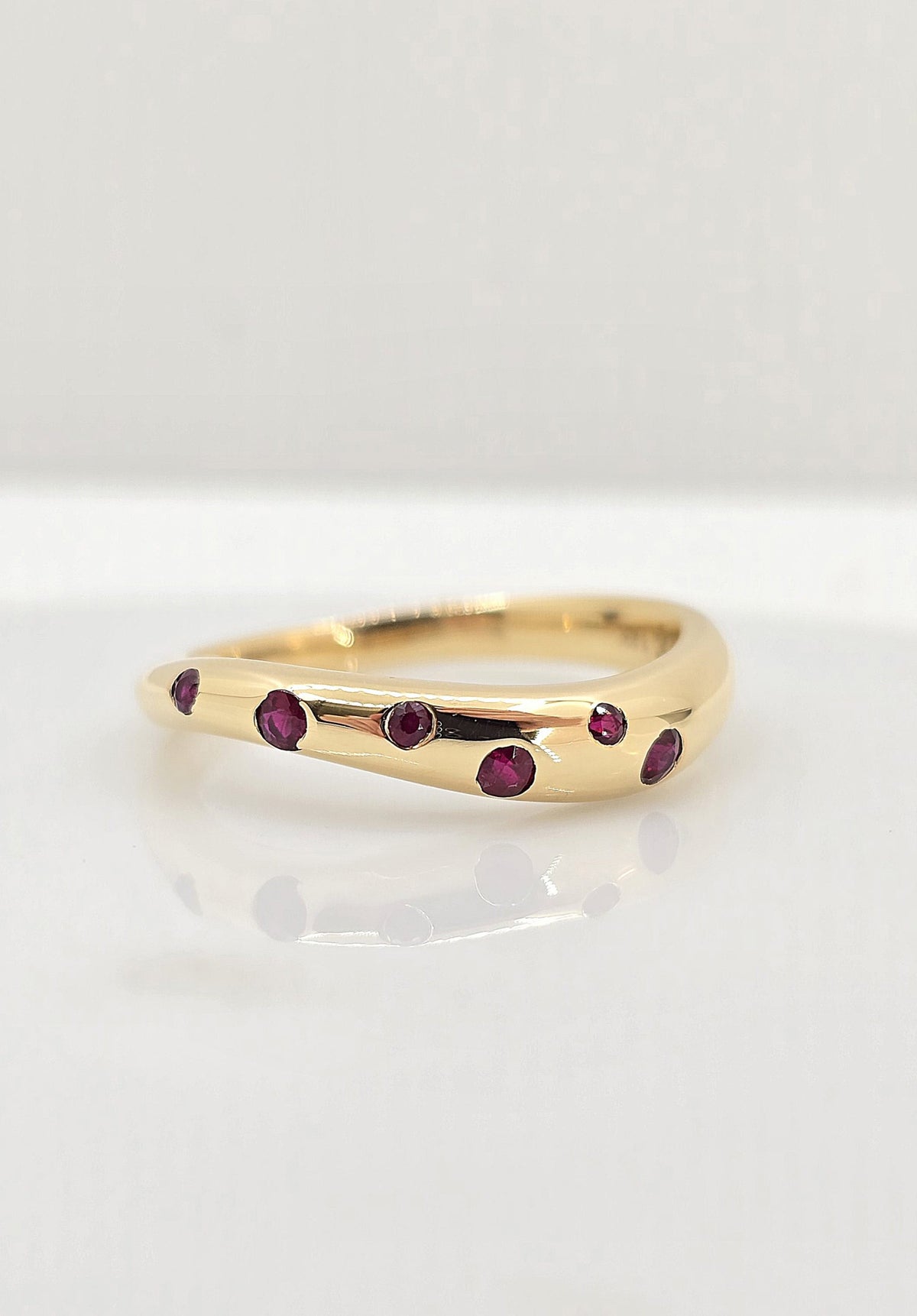 14K gold flush set ruby wave band