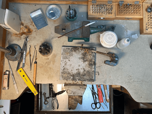 The bench top with anvils, pliers, and stamps
